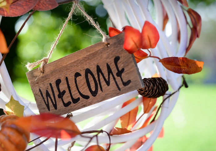 Kranz mit Herbstblättern und ein Welcome Schild